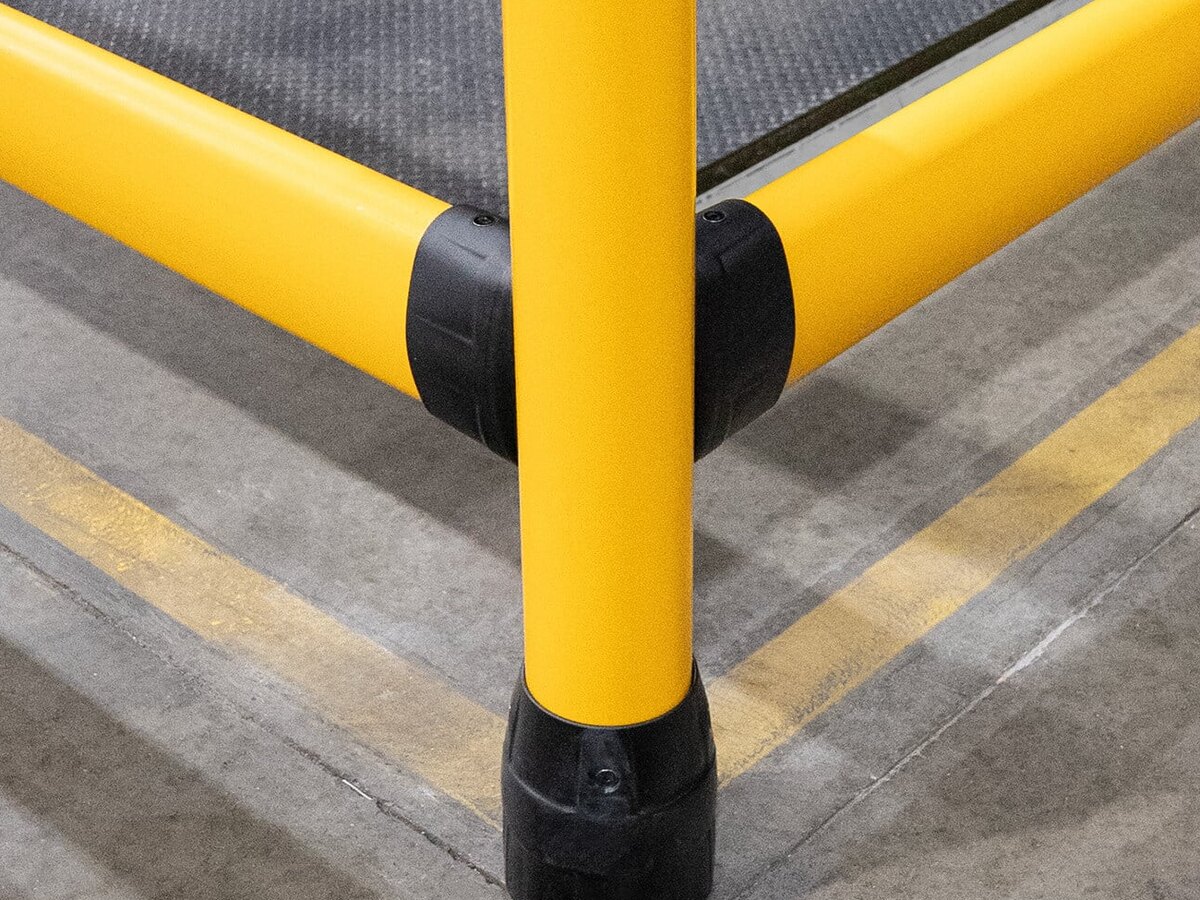 Närbild på FLEX+ FlexLink-koppling och Base i hörnet av en skyddslinje