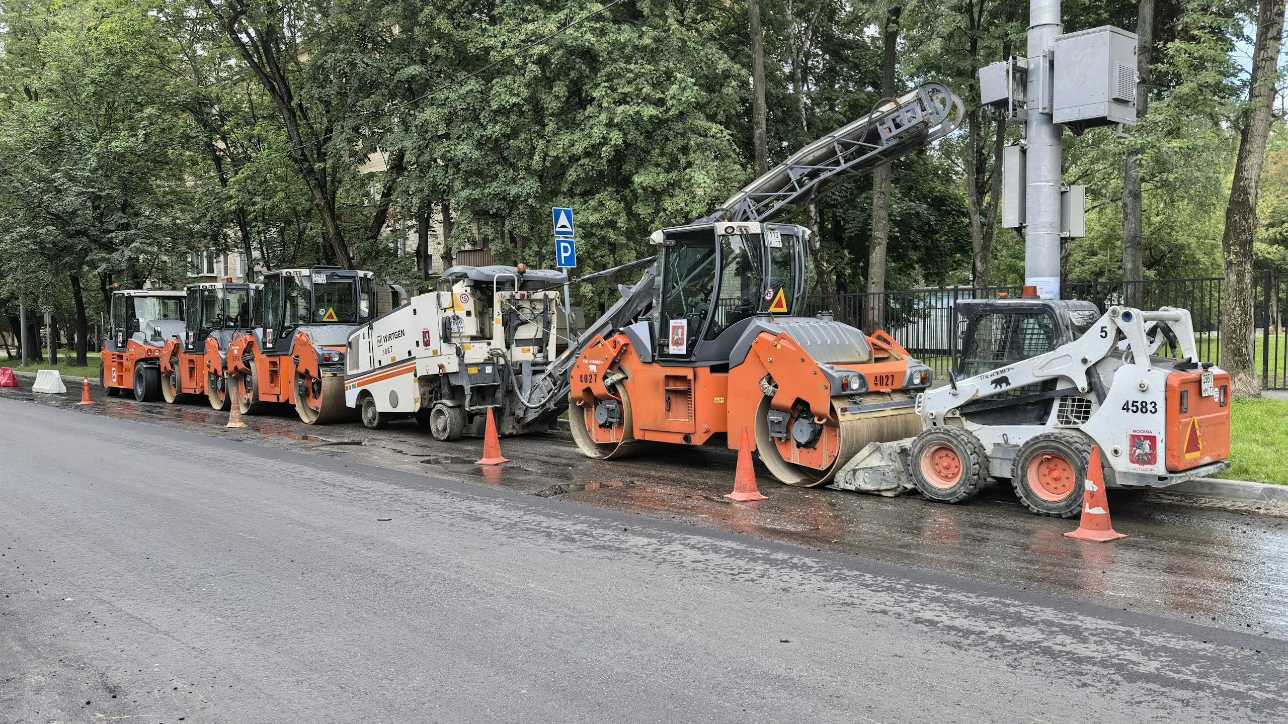Road machinery and cones at roadworks on wet asphalt